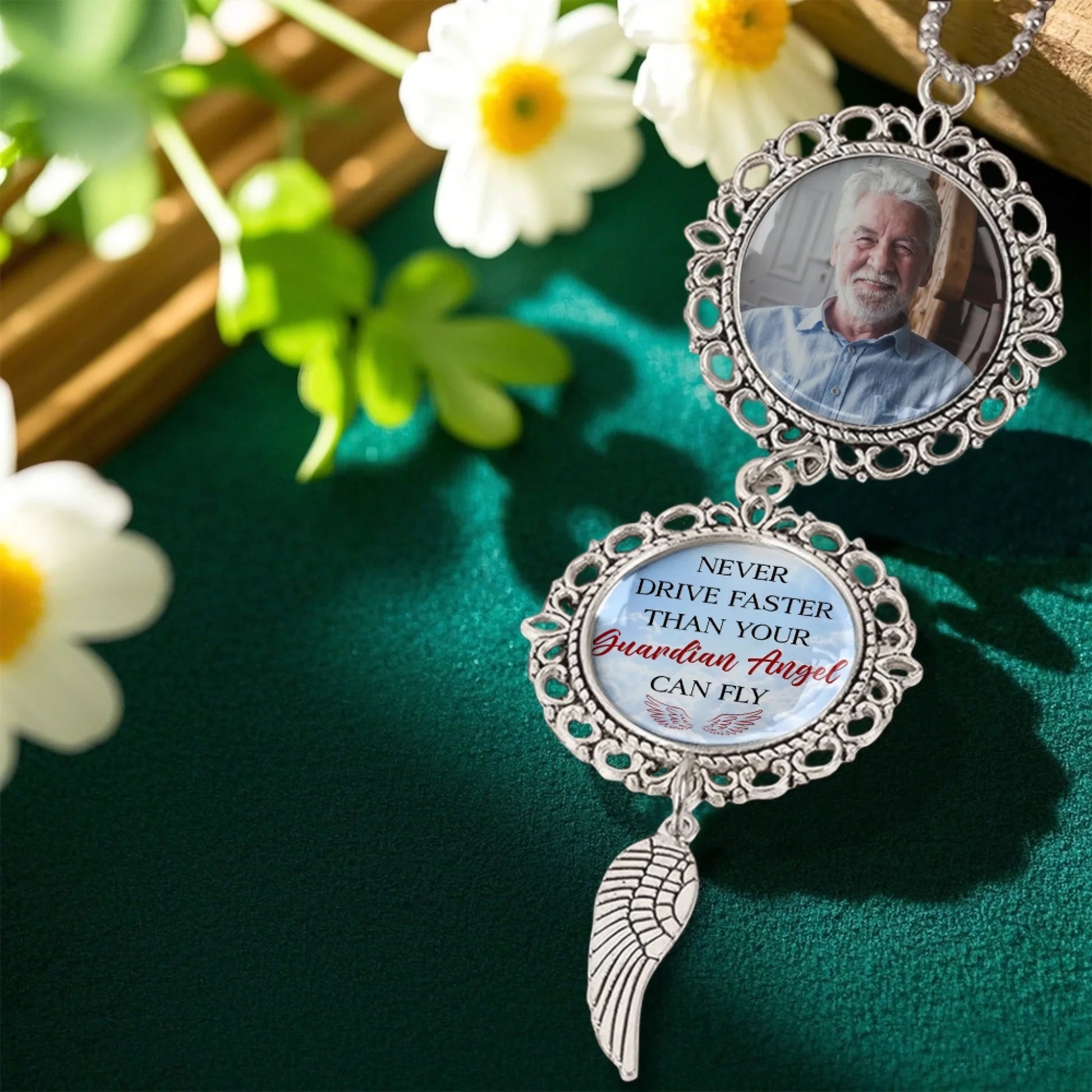 Custom memorial photo ornament with angel wing charm displayed in floral setting