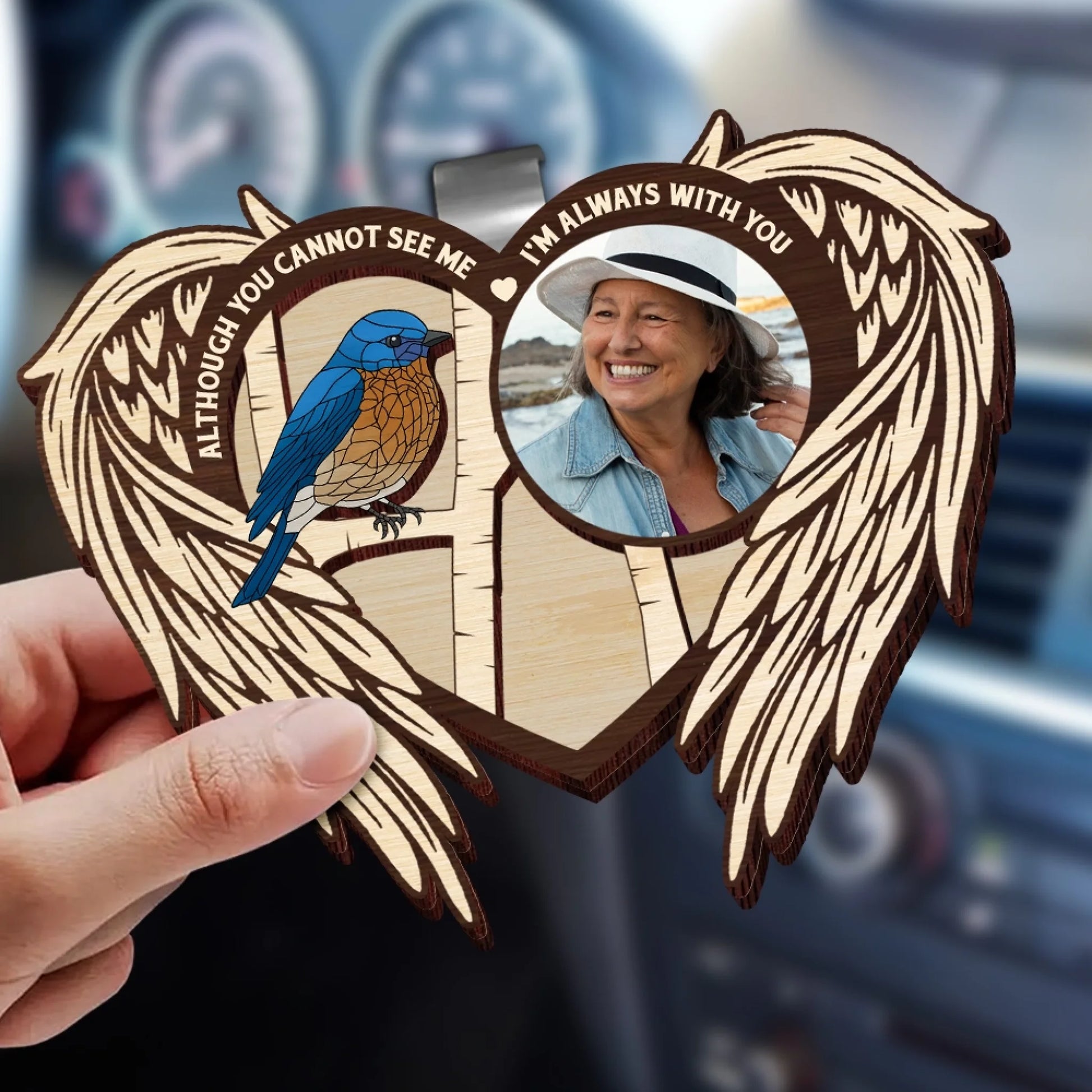 Memorial car visor clip with angel wings displayed inside vehicle