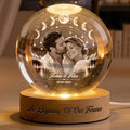 Couple crystal globe lamp glowing on a wooden base engraved with a quote