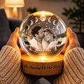 Glowing couple crystal globe lamp held in hands with warm light