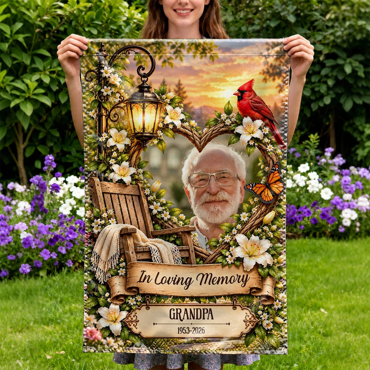Woman holding a personalized memorial flag with grandpa photo in a flower garden
