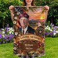 Woman holding a veteran memorial flag with In Loving Memory banner in a garden