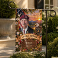 Veteran memorial garden flag with photo on a metal stand beside a stone planter