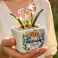 Hand holding personalized pink glass tulip pot with best friends photo