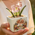 Hand holding personalized pink glass tulip pot with Christmas lantern design