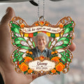 Hand holding green butterfly car hanger with papel picado and Tu luz sigue quote