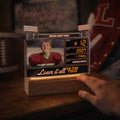 Scoreboard LED lamp glowing on a shelf next to a football