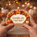 Hands holding a personalized fall memorial table sign with wooden stand