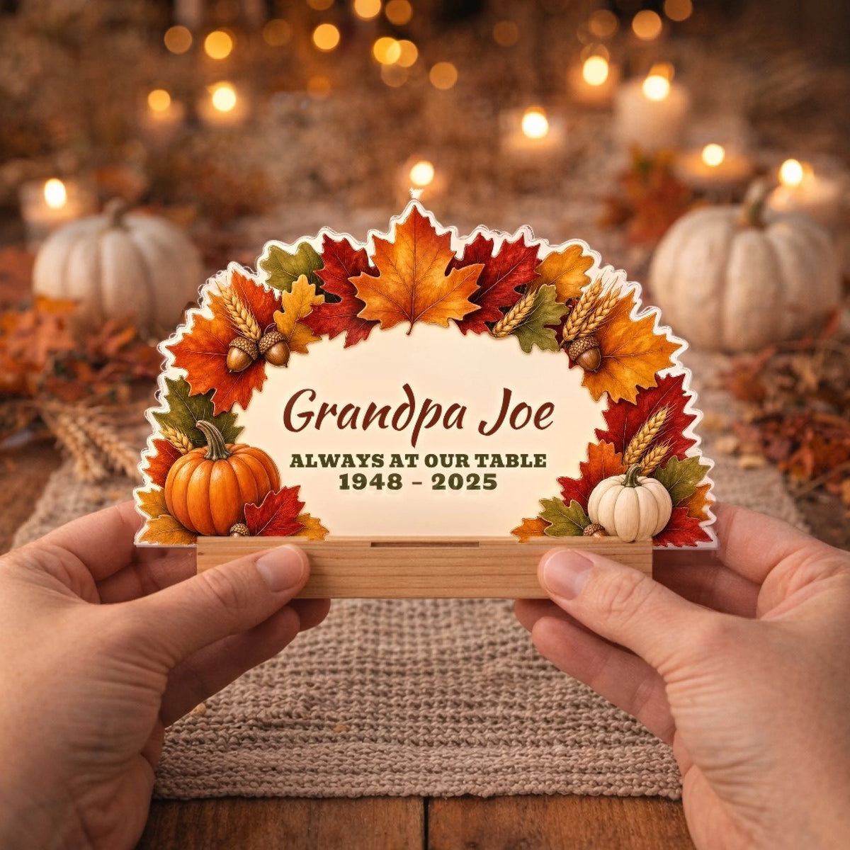 Hands holding a personalized fall memorial table sign with wooden stand