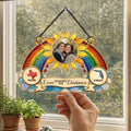 Hand holding a two states rainbow suncatcher in front of a kitchen window
