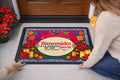Woman placing a personalized Bienvenidos posada doormat at the door