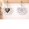 Memorial photo keychains with angel wings hanging on a wall hook