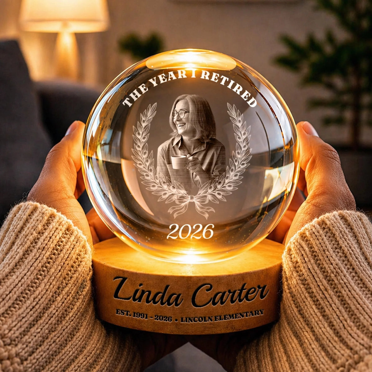 Hands holding a retirement photo globe lamp glowing warm at night