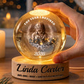 Hand holding a glowing retirement globe lamp with engraved name base
