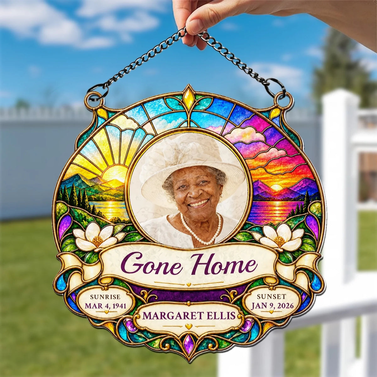 Hand holding a stained glass style homegoing suncatcher outdoors