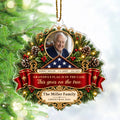 Veteran memorial ornament with photo, folded flag and red ribbon hanging on a Christmas tree