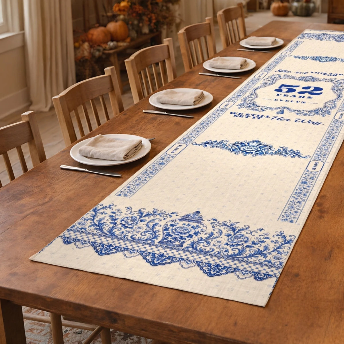 Blue and white personalized memorial table runner on a long wooden dining table with place settings