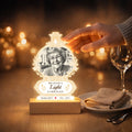 Glowing memorial night light with photo beside a plate and wine glass on a dining table