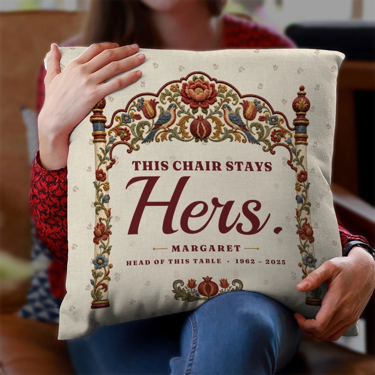 Woman holding empty chair memorial pillow with This Chair Stays Hers quote