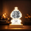 Memorial night light with woman's photo in a lamp-shaped acrylic panel on a glowing wooden base