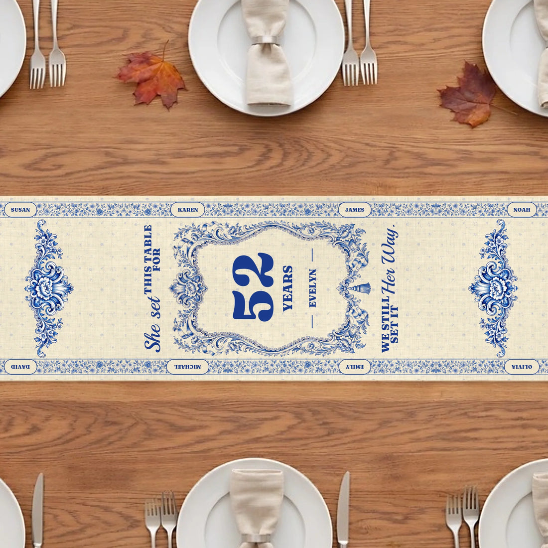 Blue and white memorial table runner with years at the table and quote on a wooden table with plates