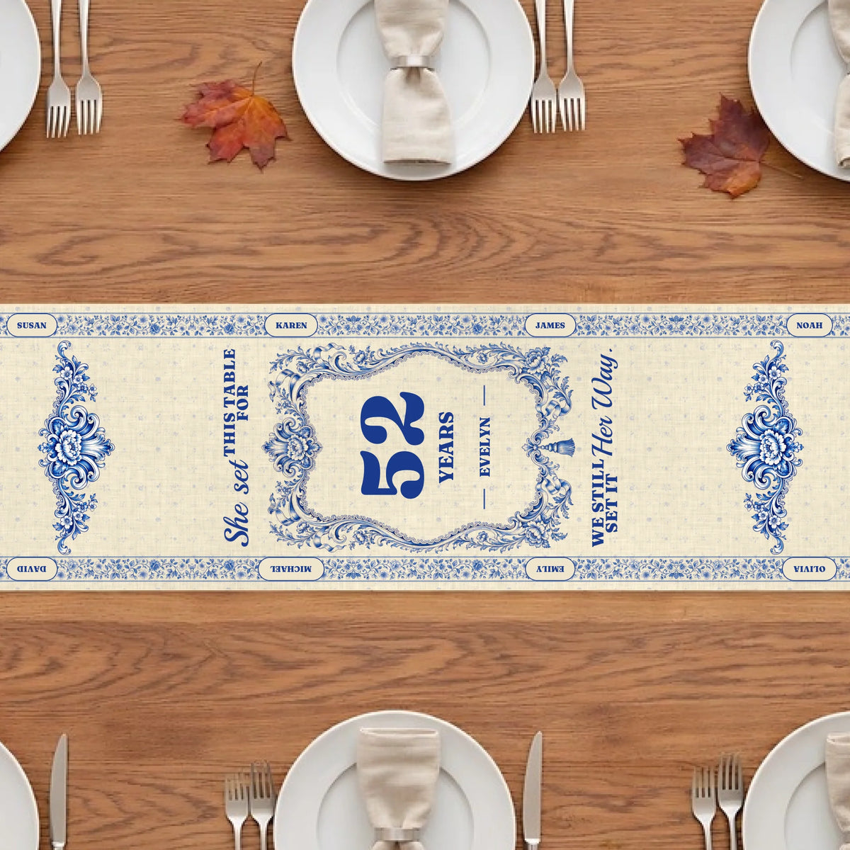 Blue and white memorial table runner with years at the table and quote on a wooden table with plates