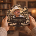 Hands holding Spanish memorial wooden plaque in a cozy living room