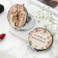 Open silver compact mirror showing photo cover and Spanish blessing back