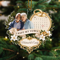 Couple photo anniversary ornament with wedding calendar hanging on pine branch