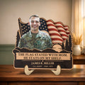 Personalized veteran memorial wooden plaque with photo, waving flag and pines on a table