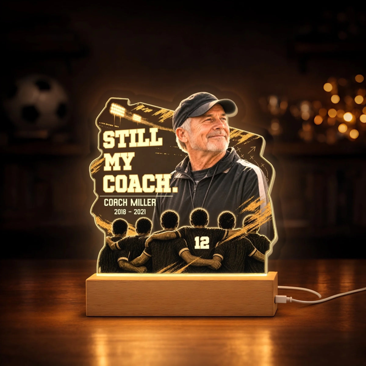 Coach memorial acrylic night light glowing on a wooden base