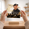 Hands holding acrylic coach memorial plaque above its wooden base