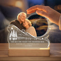 Hand above glowing memorial star map night light with wedding date